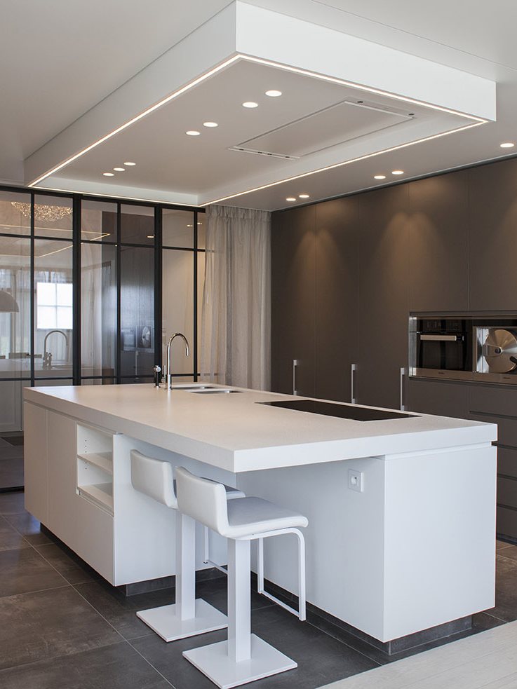 Keuken met verlaagd plafond, lijnverlichting en spots boven het eiland