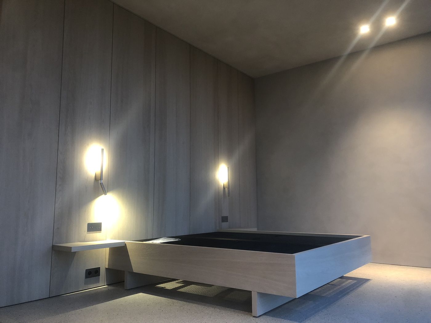 Slaapkamer met wandlampjes naast het bed