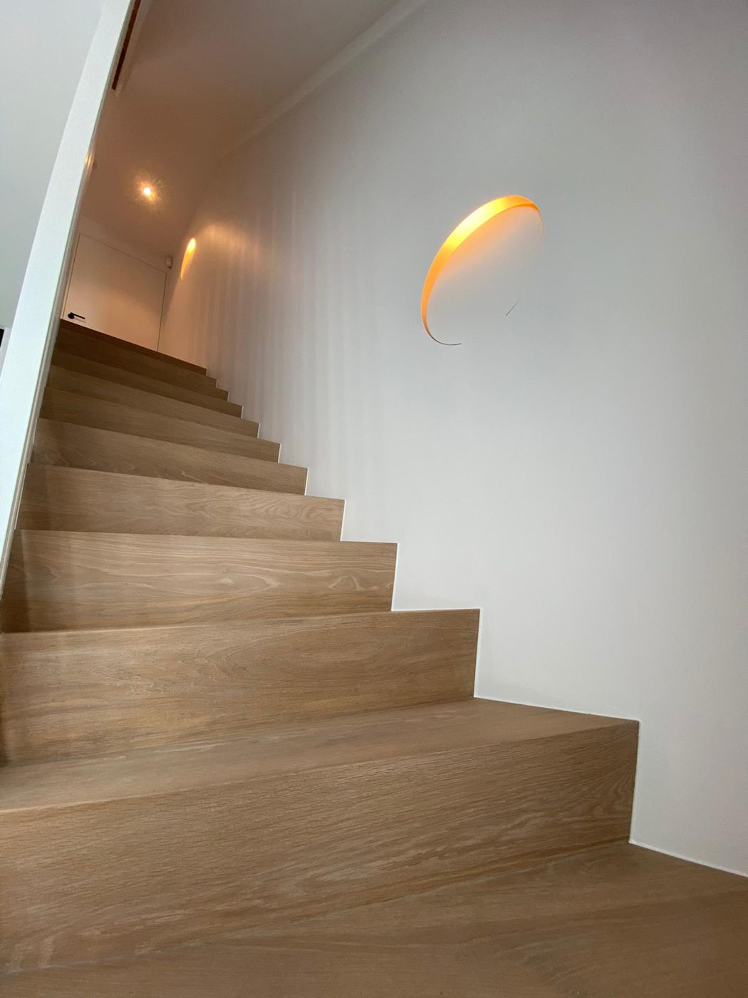 Eiken trap met verlichting in een ronde nis