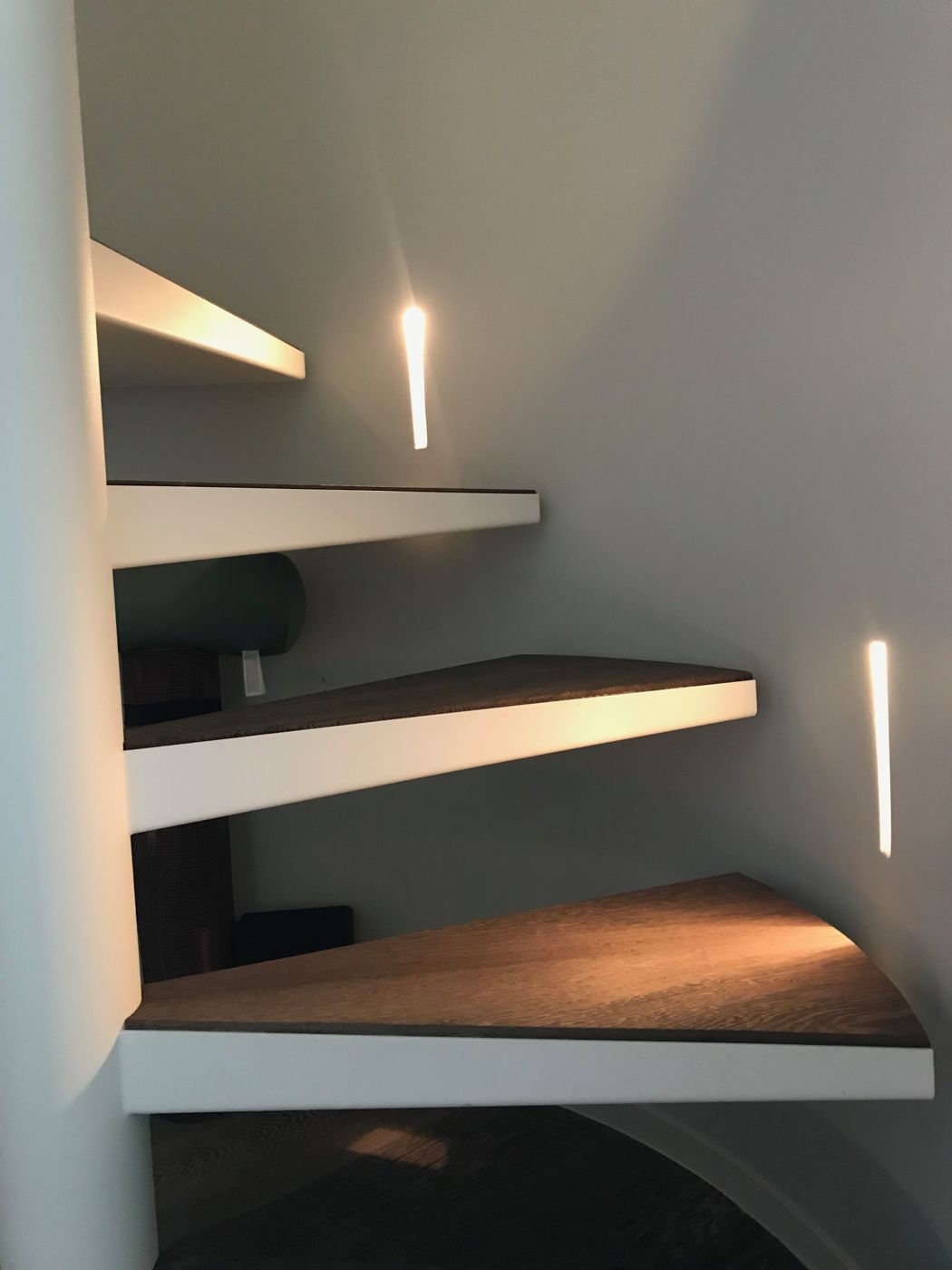 Zwevende trap met lichtsleuven in de wand